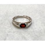 A 9ct hallmarked white gold dress ring set with oval Ruby coloured, size N, weight 2.1gm