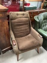 A mid 20th century armchair with ribbed brown upholstery, mahogany arm pads (collector's item only)