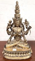 A Chinese gilt bronze figure of multi face buddha seated, height 28cm.