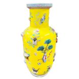A Chinese yellow ground vase, polychrome decoration of relief items such as vases, fruit baskets,