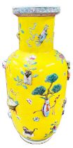 A Chinese yellow ground vase, polychrome decoration of relief items such as vases, fruit baskets,