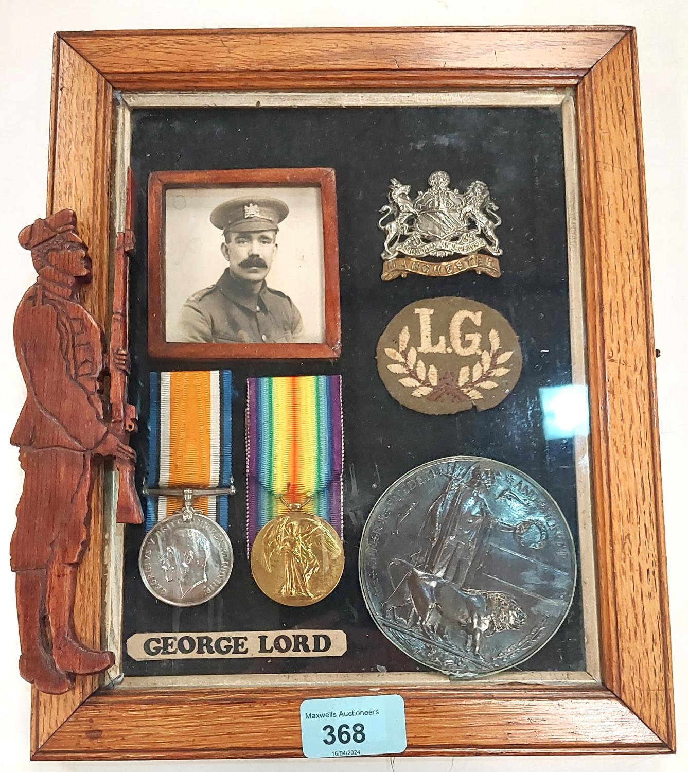 WWI pair of medals with cap badges in display frame with photograph to 29831 Pte George Lord, 1st