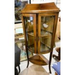 A mahogany inlaid floor standing corner display unit with bow front, double doors, shelf under