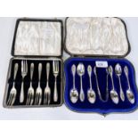 A cased set of 6 hallmarked silver teaspoons and sugar tongs with ornate monogrammed terminals,