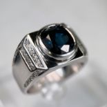 A gent's heavy dress ring with wide white metal shank set central cushion cut sapphire (10.5 x 9.