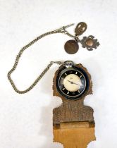 A Smiths pocket watch in wooden carved stand with steel Albert chain and medals