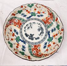 An Imari shallow dish decorated in polychrome with flowers and branches, signature to base, dia.