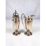 A two piece hallmarked silver "strawberry set" comprising cream jug and sugar dredger with ribbed