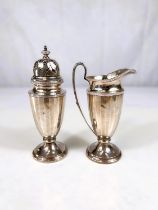 A two piece hallmarked silver "strawberry set" comprising cream jug and sugar dredger with ribbed
