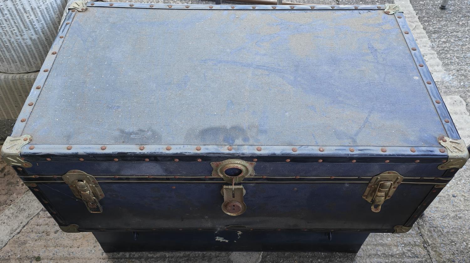 A blue cabin trunk and a metal cabin trunk