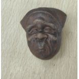 A Japanese pottery netsuke in the form of a face