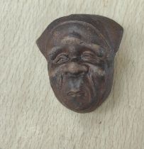 A Japanese pottery netsuke in the form of a face