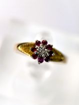 An 18 carat hallmarked gold dress ring illusion set with red and clear stones, 2.8gm size N/O