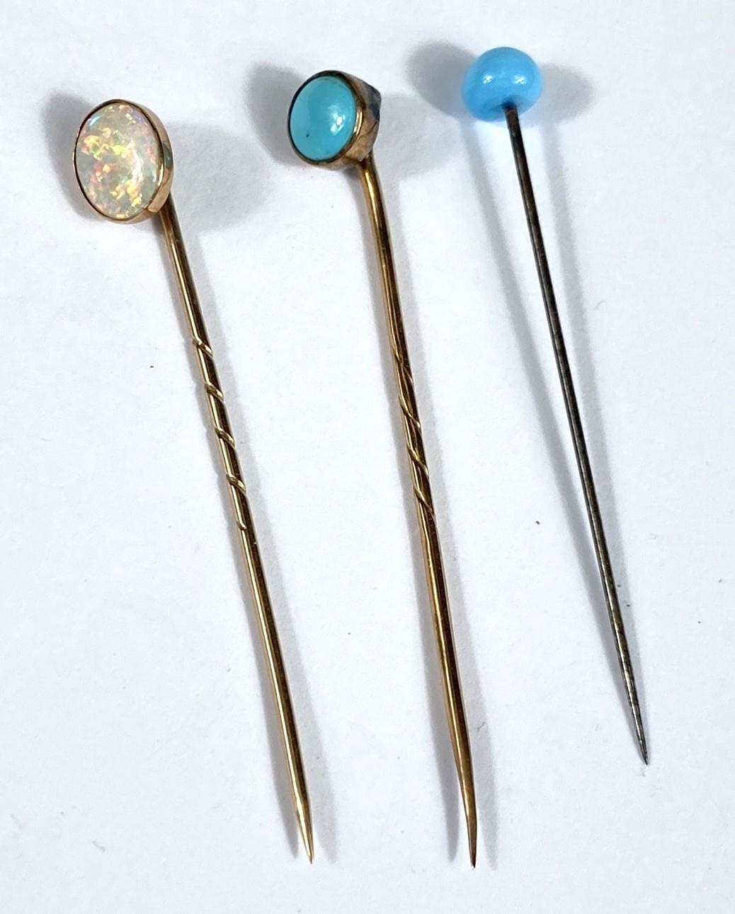 A cased opal and 9ct gold stick pin and two others set with Turquoise stones cased