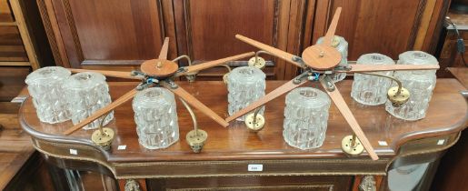 A pair of mid 20th century teak star shaped light fittings with glass shades