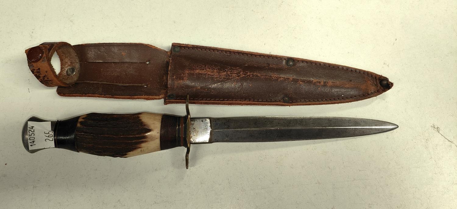 An Early 20th century Fairbairn style fighting knife with horn handle and leather sheath