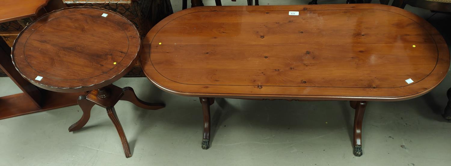 A reproduction yew wood coffee table with rounded rectangular top and twin pedestals on splay