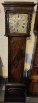 An early 20th century oak longcase clock with barley twist columns to the hood, with square brass