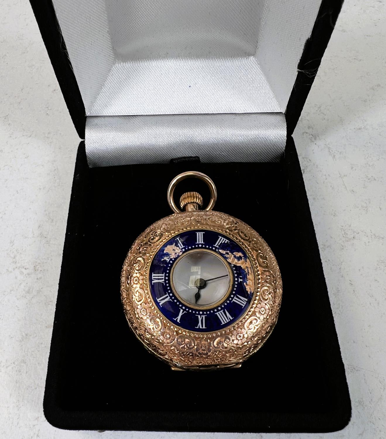 A chased yellow metal hunter fob watch with blue enamel decoration, white dial and backplate stamped