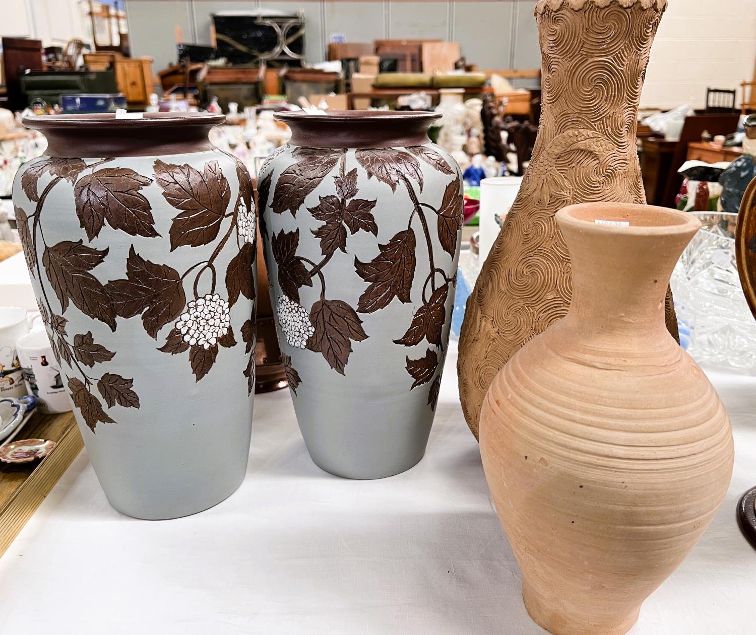 A pair of late 19th/early 20th century tapering stoneware vases with cut back and applied decoration