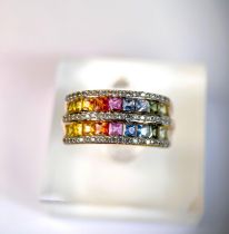A 9 carat hallmarked dress ring with 3 bands of clear stones and 2 bands of rainbow coloured stones,