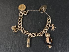 A heavy curb chain charm bracelet with 9 carat hallmarked gold heart lock, 4 charms (2 x 9ct hmg)