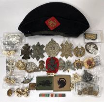 A collection of military badges and buttons and a military beret