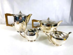 An Arts & Crafts hallmarked silver planished silver tea service of circular form with bud finials,