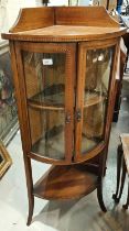 A mahogany inlaid floor standing corner display unit with bow front, double doors, shelf under