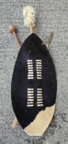 A 20th century tribal wall hanging comprising hide shield, spear and club