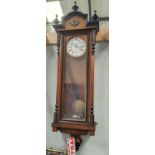 A 19th century walnut Vienna wall clock with ebonised mouldings and finials with double weight