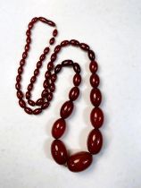 A string of cherry amber bakelite graduating beads, total length 79cm, smallest bead 1cm, largest