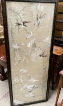 A large Chinese embroidered picture depicting birds in branches, 137 x 51cm framed and glazed