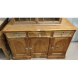 A Victorian stripped pine dresser base with 3 frieze drawers and triple arched cupboard drawers