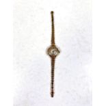 A 9ct hallmarked gold ladies wrist watch on yellow metal strap, strap stamped 9ct, gross weight