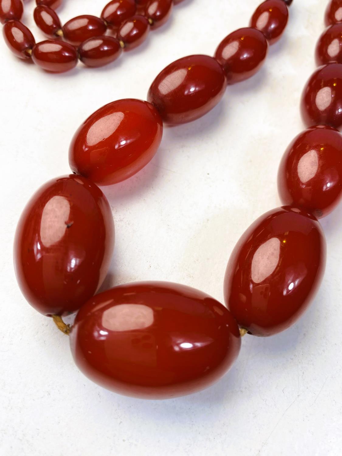 A string of cherry amber bakelite graduating beads, total length 79cm, smallest bead 1cm, largest - Image 2 of 3