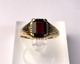 An 18 carat hallmarked gold gent's ring set large cushion cut garnet coloured stone. 6gm, size W/X