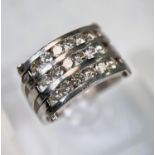 A gent's dress ring with wide white metal pierced shank, the top set with 3 bands of diamonds, 18 in
