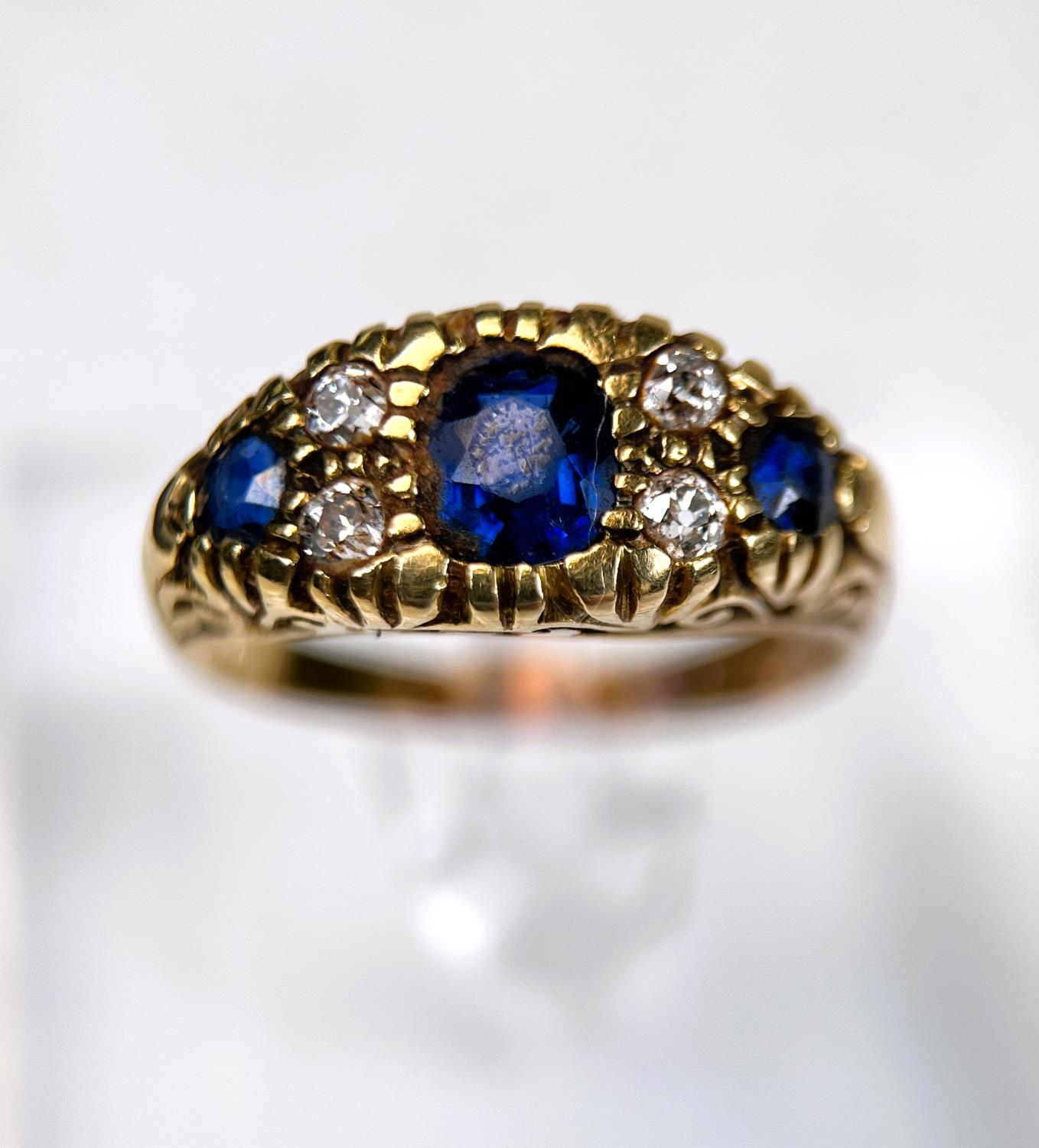 A Victorian style 18ct hallmarked gold sapphire and diamond ring, length of central stone, approx
