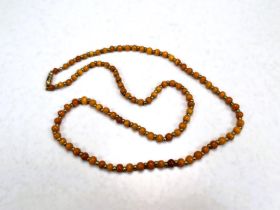 A string of 19th century yellow amber beads with gilt metal spacers , 64cm, 18gm approx.