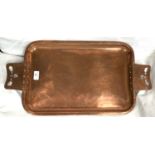 A rounded rectangular Arts & Crafts style copper tray with riveted and pierced handles