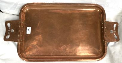A rounded rectangular Arts & Crafts style copper tray with riveted and pierced handles