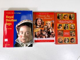 3 Royal Doulton character jug collectors books and 2 miniature wall shelf display units