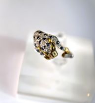 A 9ct hallmarked gold ring in the form of a leopard pouncing set with small sapphires and illusion