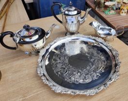 A Sheffield silver plate chased circular tea tray with floral border and a matched 3 piece silver