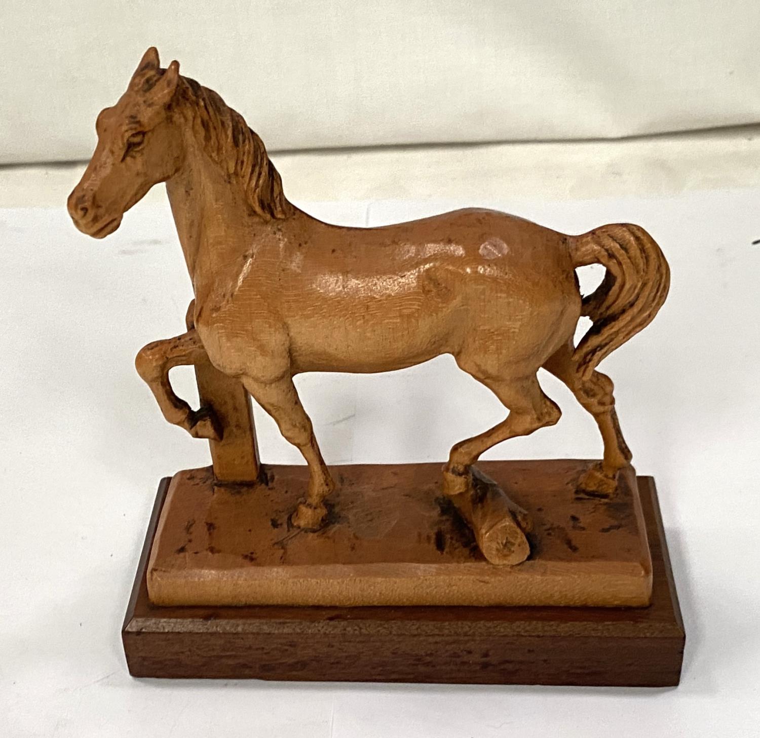 A carved horse possibly by Faust, Wharton & Lang, length 12cm on plinth