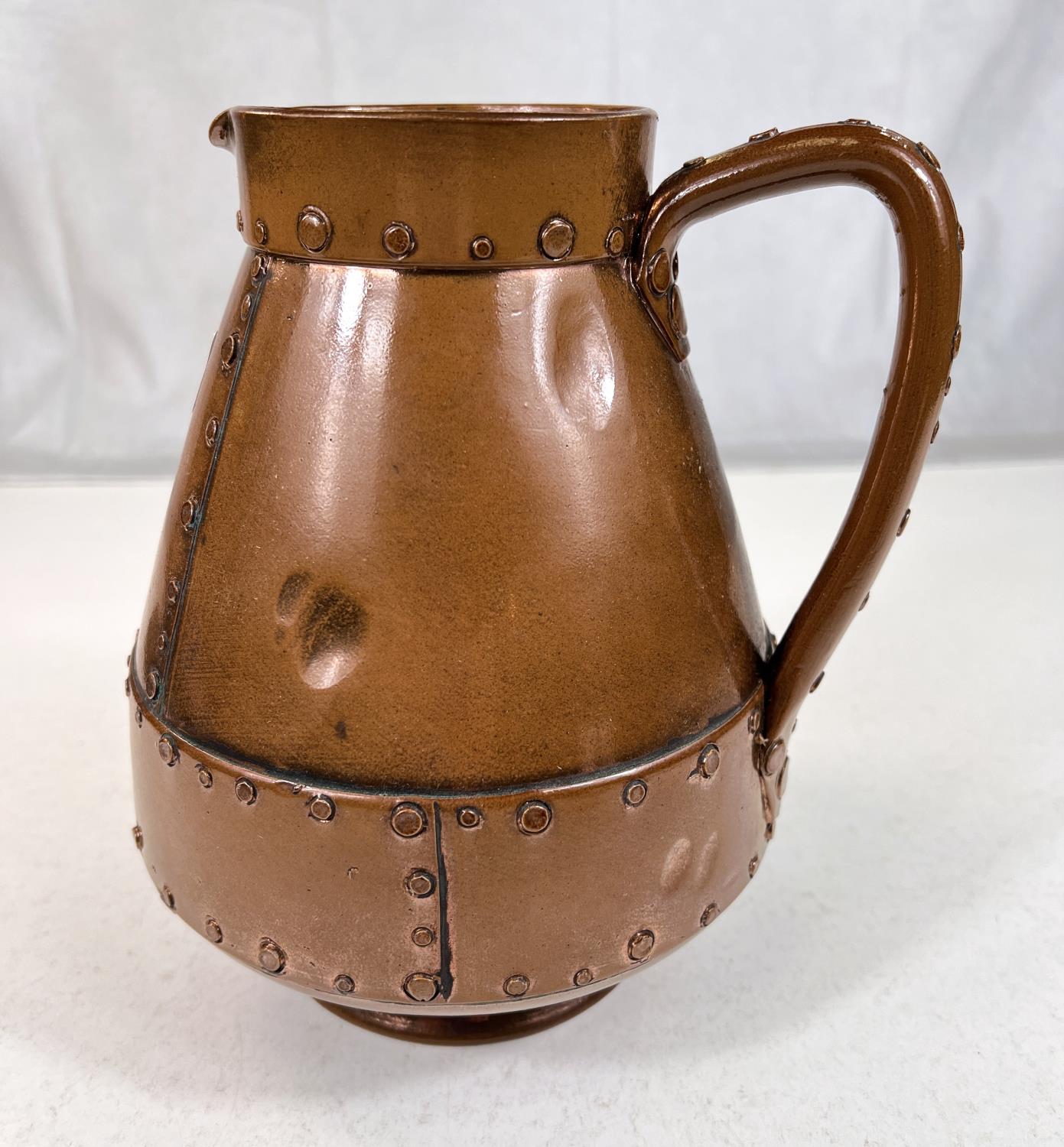 An unusual Arts & Crafts jug by Doulton Silicon in copper coloured finish with rivet decoration, ht.