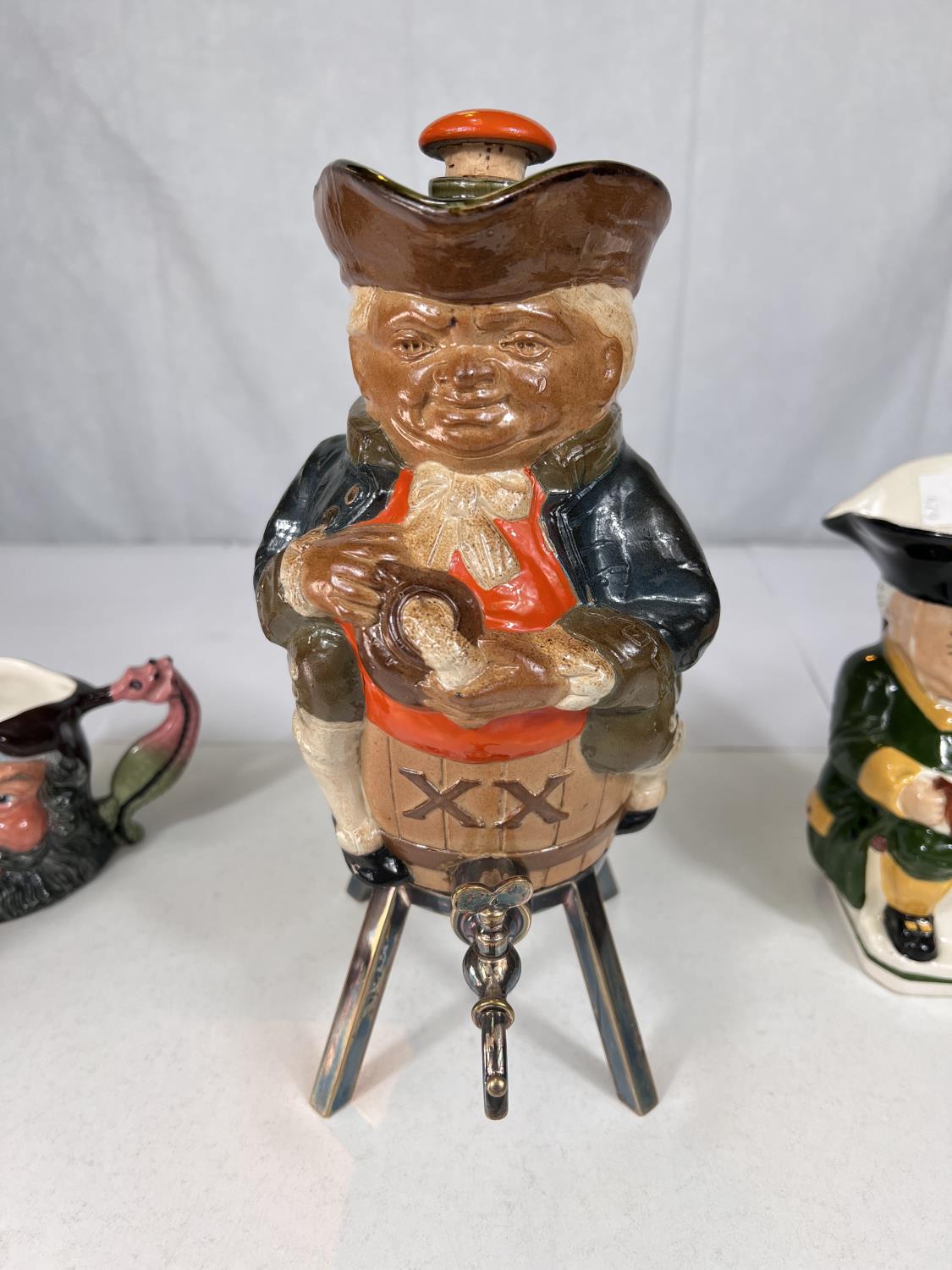 A novelty Doulton stoneware decanter in the form of a man sitting astride a barrel, tap under and - Bild 2 aus 4