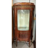 A Louis XVI style bow front walnut display cabinet with ormolu mounts figured reserve panels and