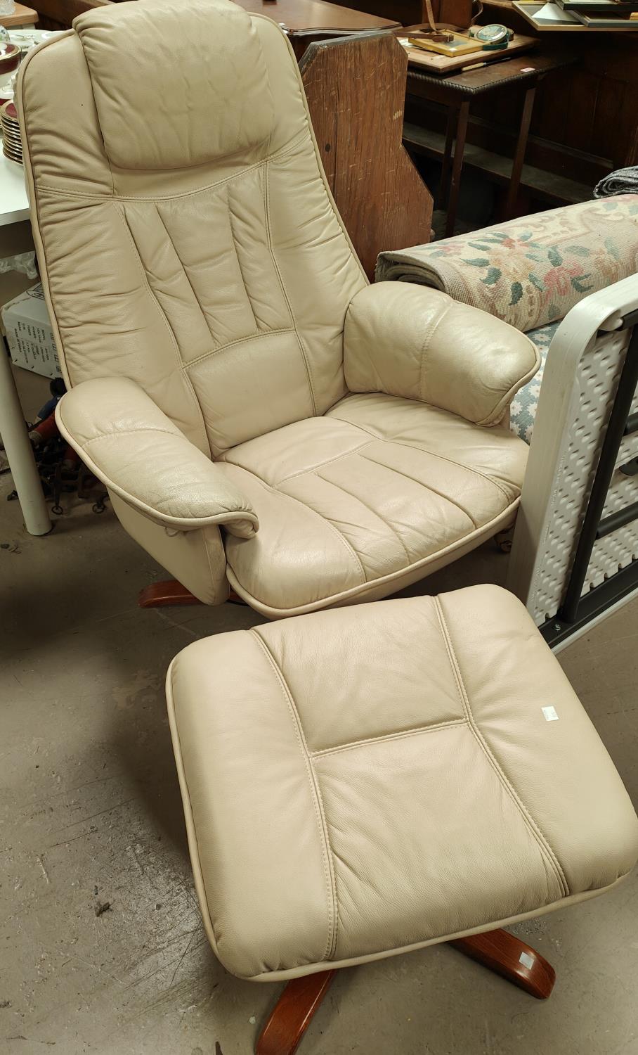A "Mobel Team" swivel rocking chair with stool in cream hide